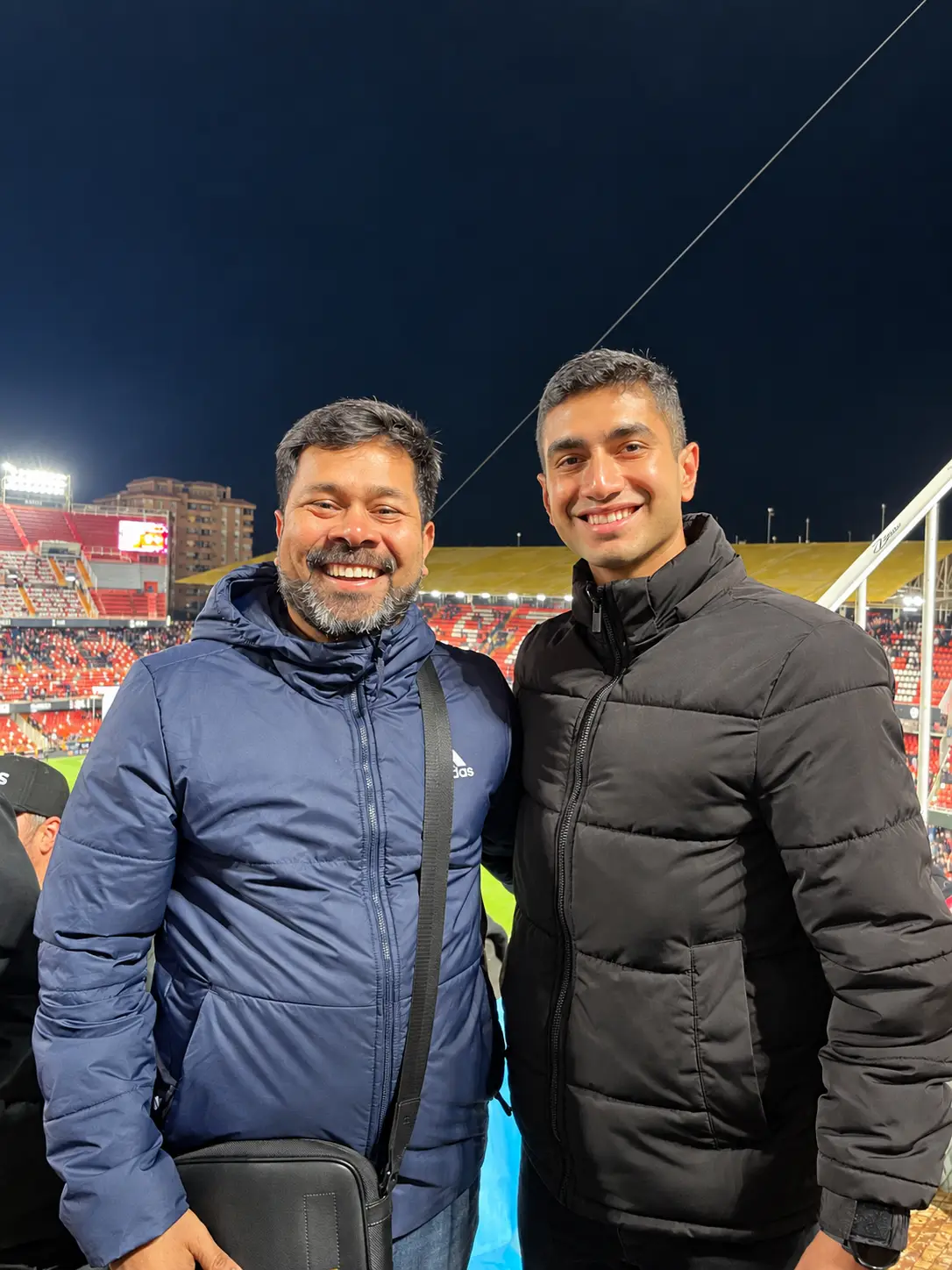 An Xdrona player and mentor at a floodlit stadium in the evening.