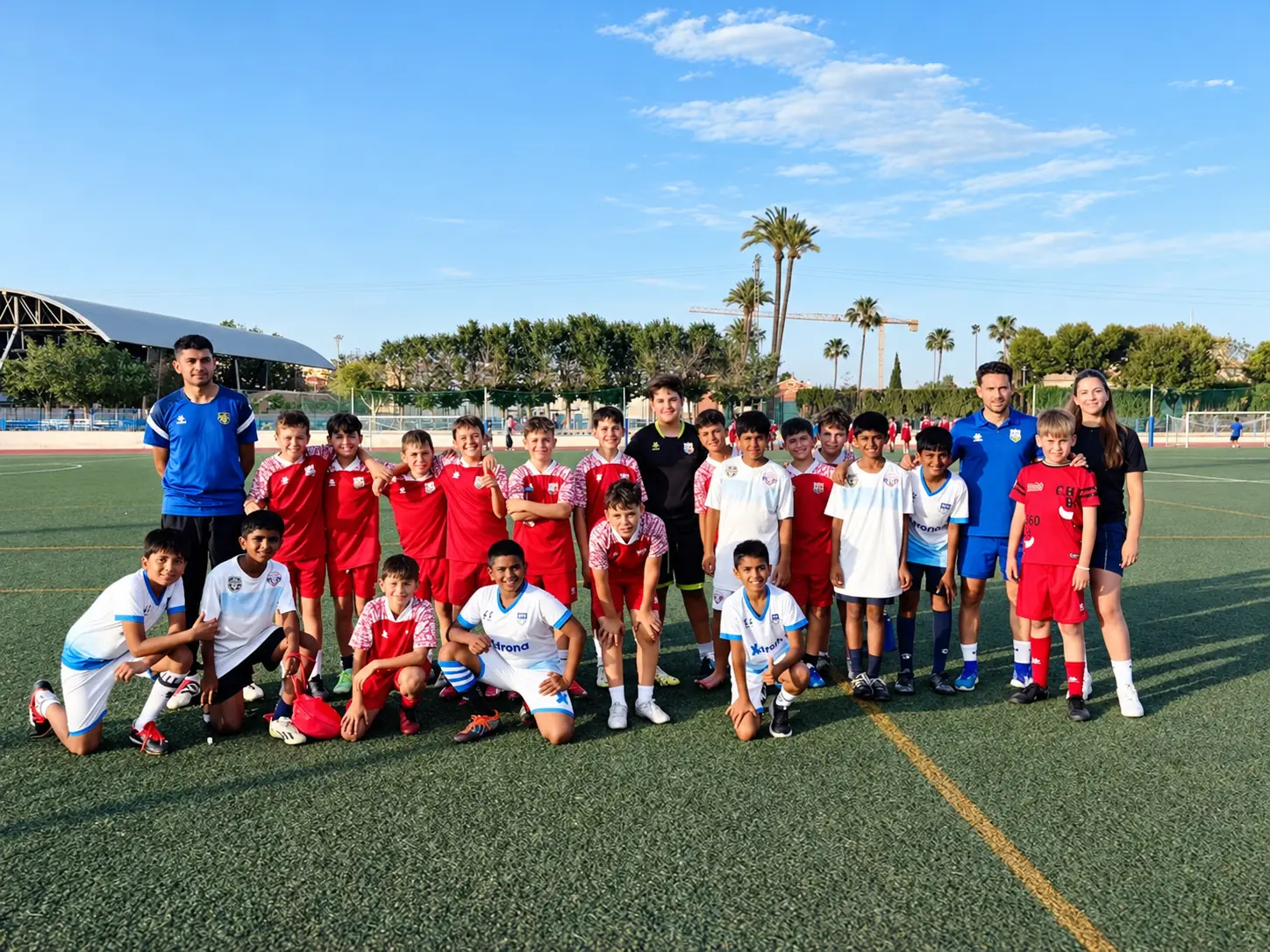 Xdrona players and coaches after an evening match at a Spanish academy pitch.